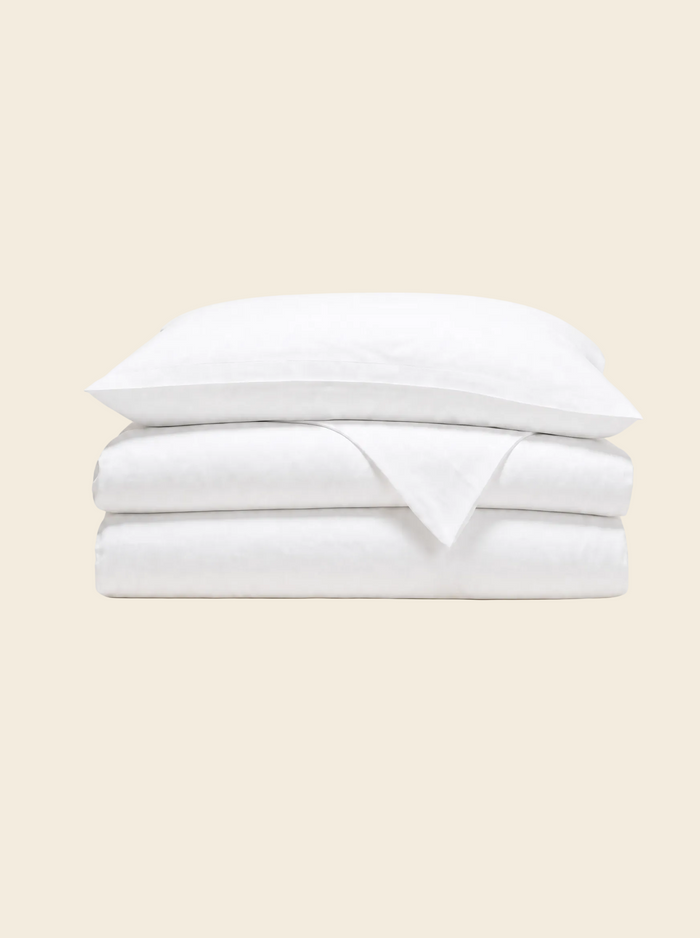 King duvet cover in natural white, folded with a pillowcase resting on top