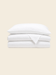 King duvet cover in natural white, folded with a pillowcase resting on top
