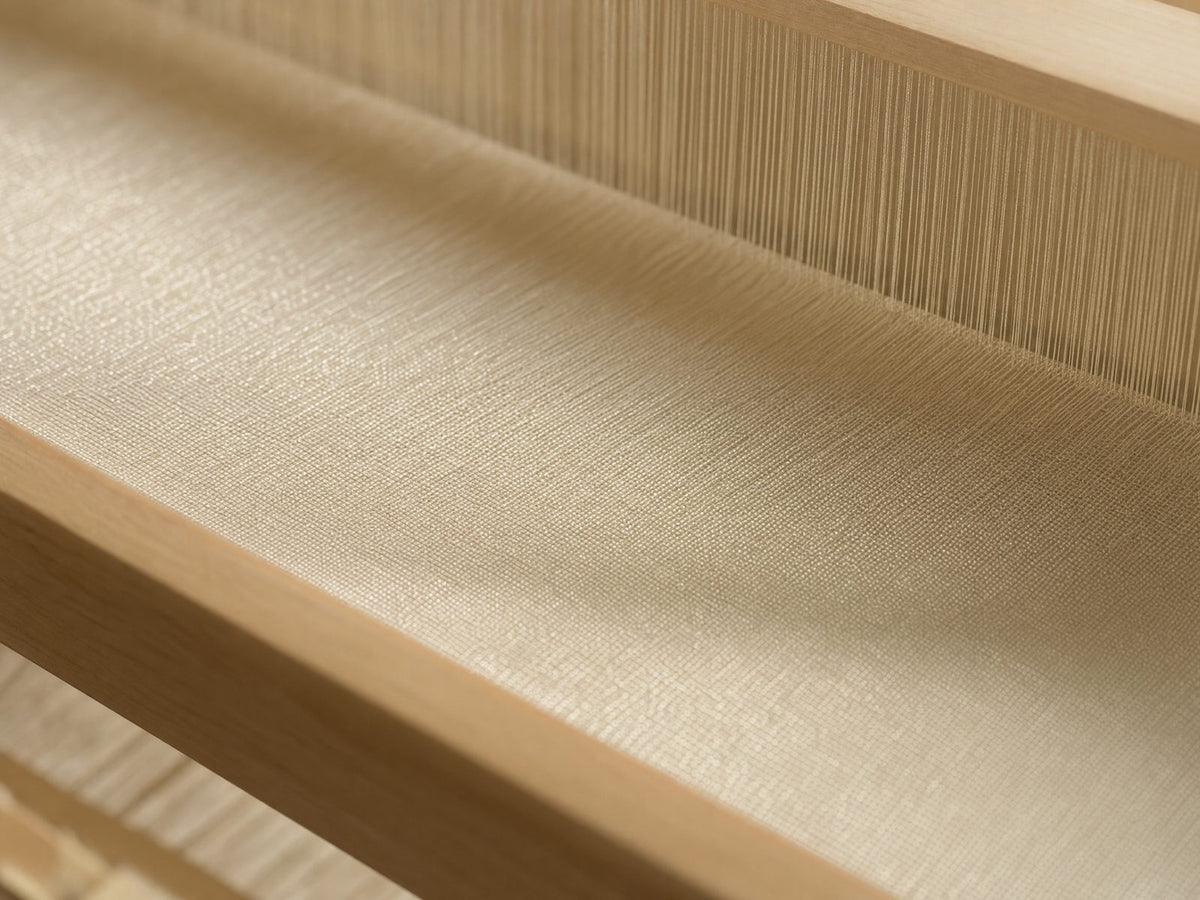 Warp threads on the loom, woven into cloth